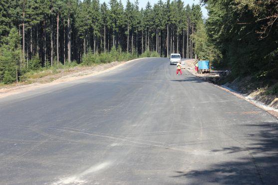 O víkendu stavbaři na silnici přes Pasa položili poslední asfaltovou vrstvu 