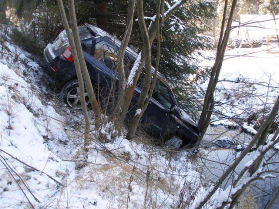 Auto zůstalo po smyku viset ve svahu nad potokem