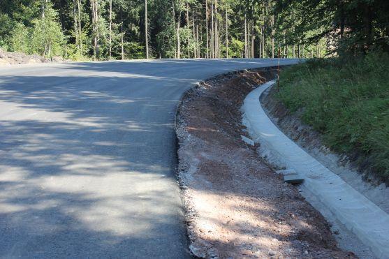 O víkendu stavbaři na silnici přes Pasa položili poslední asfaltovou vrstvu 